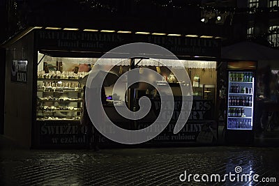 Krakow, Poland - December 22, 2014: Rear view of a woman in winter jacket holding an umbrella in front of waffle shop during Stock Photo