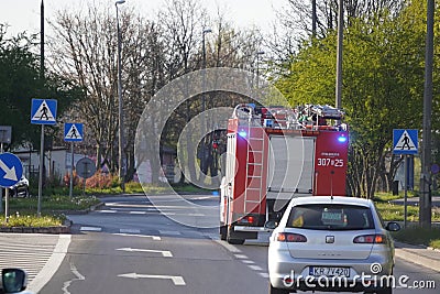 Krakow, Poland 22.04.2020: a Fire truck with flashing lights goes to help people on city streets, put out a fire or rescue. Skip Editorial Stock Photo