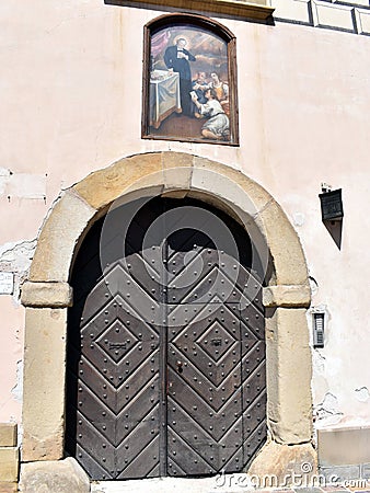 A heavy studded doorway with a painting mounted above in the courtyard of Wawel Castle Editorial Stock Photo