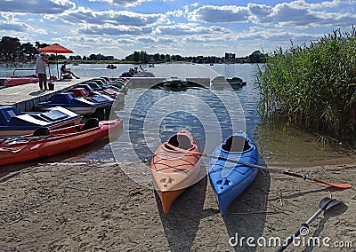 Krakow, Poland: Wide angle shot of couple of kayak for rent kept at dock with it`s paddle in the man made lake Editorial Stock Photo