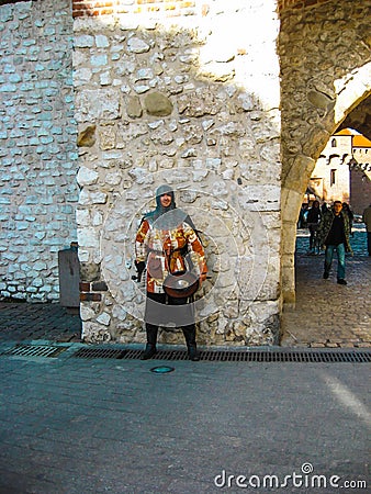Krakow, Poland - October 09, 2012: The past in the present. Medieval city guard at the gates of the city Editorial Stock Photo