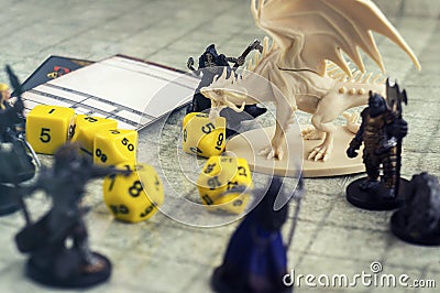 Playing Dungeons and Dragons. Miniature fugures of rpg characters, dices and dragon Stock Photo