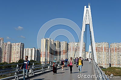 People walk on the Pavshinsky pedestrian bridge over the Moscow river in Krasnogorsk near Moscow Editorial Stock Photo