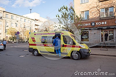 A doctor will climb into a yellow ambulance that stands on Mira Avenue, in the center of Krasnoyarsk, near the cafeteria in the Editorial Stock Photo