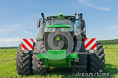 Krasnoyarsk, Russia - July 02, 2021: Modern John Deere tractor in the field before work. Front view Editorial Stock Photo