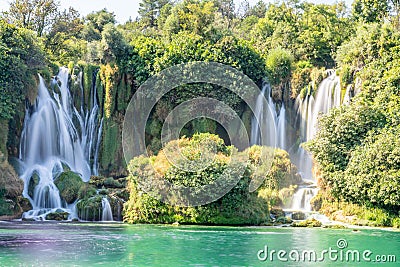 Kravica karst forest waterfall flows with lake in the foreground, Trebizat river, Bosnia and Herzegovina Stock Photo