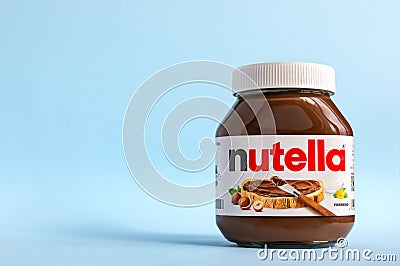 Nutella in a glass jar on a blue background. Editorial Stock Photo