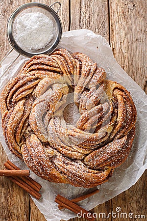 Kringle Delicious Brioche with sugar and cinnamon closeup on the paper. Vertical top view Stock Photo