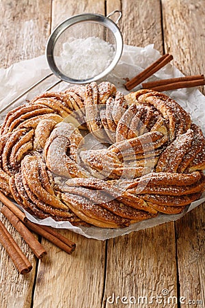 Kringle Delicious Brioche with sugar and cinnamon closeup on the paper. Vertical Stock Photo