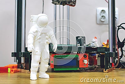 Kropivnitskiy, Ukraine Ã¢â‚¬â€œ 12 may, 2018: 3D printed astronaut, cosmonaut on the background of three dimensional 3d printer. Stock Photo