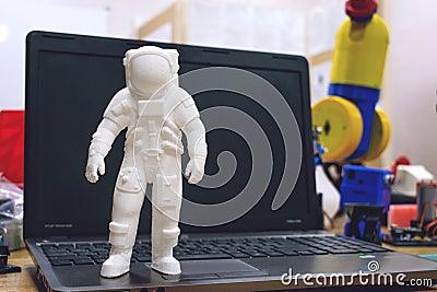 Kropivnitskiy, Ukraine â€“ 12 may, 2018: 3D printed astronaut, cosmonaut, robot on the background of devices and laptop. Spaceman Stock Photo