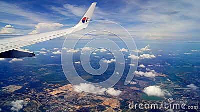 KUALA LUMPUR, MALAYSIA - APR 11th, 2015: Wing view during flight with a airplane with blue skys and clouds Editorial Stock Photo