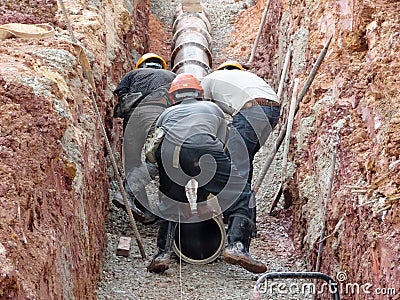 Underground sewerage pipe installed by construction workers at the construction site. Editorial Stock Photo