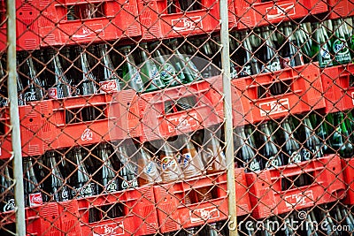 Full bottles of Coca Cola in red plastic box behind the net Editorial Stock Photo