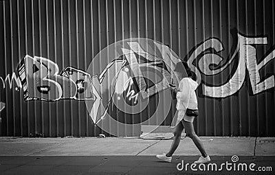 Girl walking and graffit on the background Editorial Stock Photo