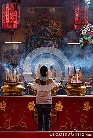 Woman Praying In A Chinese Temple In Kuala Lumpur, Malaysia Editorial Stock Photo