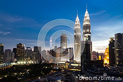 KUALA LUMPUR, MALAYSIA - JULY 23, 2016: View of the Petronas Twin Towers and KL Tower at KLCC City Center during dusk hour. The Editorial Stock Photo