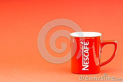 Red Nescafe mug isolate on red background. Editorial Stock Photo