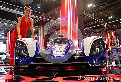 Model posed with Toyota TS030 hybrid racing car produced by Toyota at Toyota booth Editorial Stock Photo