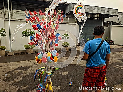 Kudus - Indonesia, February 13 2022: A seller in a street market sold colorful handmade traditional toys in Kudus, Indonesia Editorial Stock Photo
