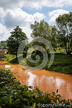 Kuks, East Bohemia, Czech Republic, 10 July 2021: Elbe River after rain with yellow, dark orange water similar to rust at sunny Editorial Stock Photo