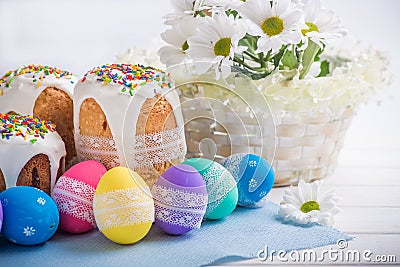Kulich, Russian Ukrainian Easter cake with colored eggs lace ribbon on white wooden background Stock Photo