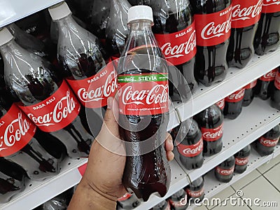 KULIM,MALAYSIA - CIRCA OCTOBER,2019 : A hand holding a bottle of Coca Cola stevia at supermarket Editorial Stock Photo