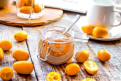 Kumquat on plate and jam in jar at wooden table Stock Photo