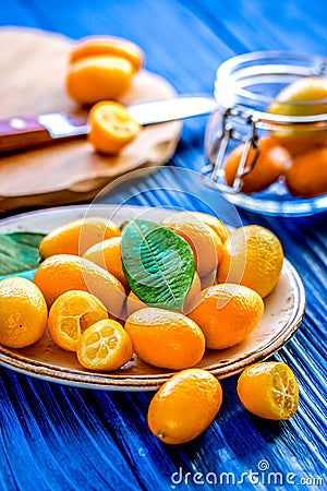 Kumquat on plate at wooden table Stock Photo