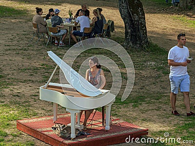 Lady playing white piano, village charity event Editorial Stock Photo