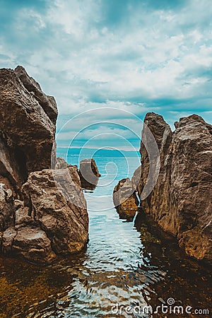 Kvarner gulf of Adriatic sea rocky coastline, large rocks at shoreline in old town of Lovran in Croatia Stock Photo
