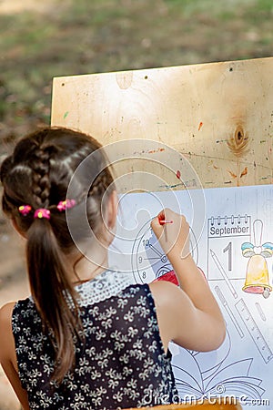 Kyiv - September 2019: Girl draws a coloring book with until September 1 Editorial Stock Photo
