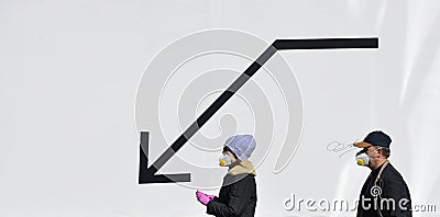 A man and a woman wearing a masks walks past a black arrow pointing downwards Editorial Stock Photo