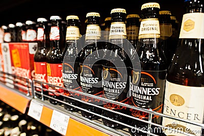 Kyiv, Ukraine - December 19, 2018: Bottles of Guinness beer on supermarket stand shelves. Guinness is an Irish dry stout that Editorial Stock Photo