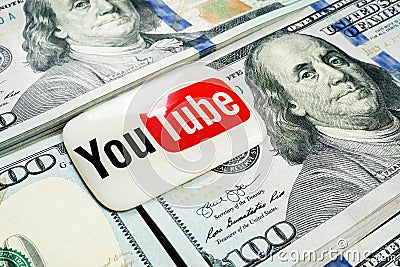 Kyiv, Ukraine - July 30, 2020: YouTube logo lies on the wads of money. Earnings by video blogging. Editorial Stock Photo