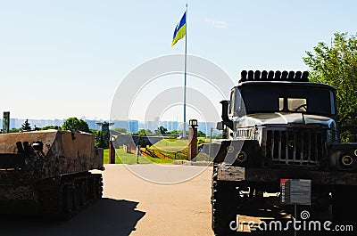 Xhibition of destroyed russians armored vehicles. The biggest National flag of Ukraine in the background Editorial Stock Photo
