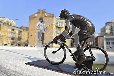 Kyiv, Ukraine - March 28, 2021. Bronze mini - sculpture of a cyclist against the background of a cyclist's mural Editorial Stock Photo