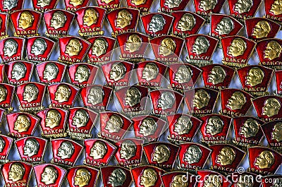 Vintage badges of members of the Komsomol - the silhouette of Lenin on the background of the red banner. Background from the Komso Editorial Stock Photo