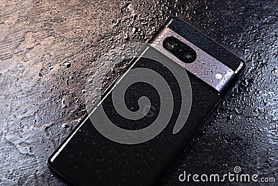 KYIV, UKRAINE - October 03, 2023 : Modern smartphone Google Pixel with water drops on black background. Water resistant modern Editorial Stock Photo