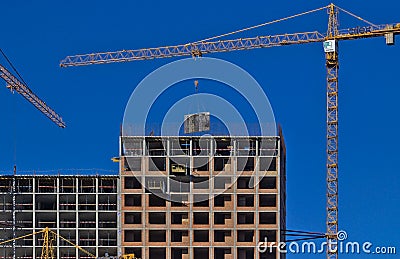 On the top floor of the new building under construction, large-sized structures are installed using a crane. Editorial Stock Photo