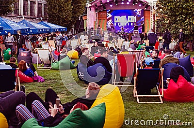 Kyiv, Ukraine - September 22, 2019. Comic Con. People sitting on colorful bean bag chairs, relaxing and chating outdoors Editorial Stock Photo