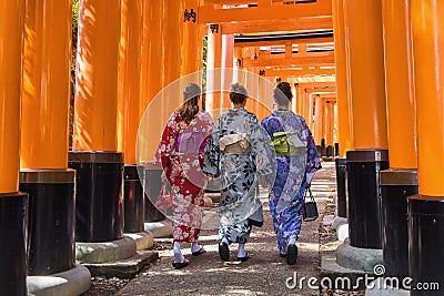 three European women in Kimono walking through Torii path at Fushimi Inari-Taisha Shrine, Kyoto, Japan Editorial Stock Photo