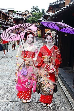 Young Japanese girls dressed in geisha`s custom taking a walk in the stone-paved roads of Ninenzaka and Sannenzaka Editorial Stock Photo