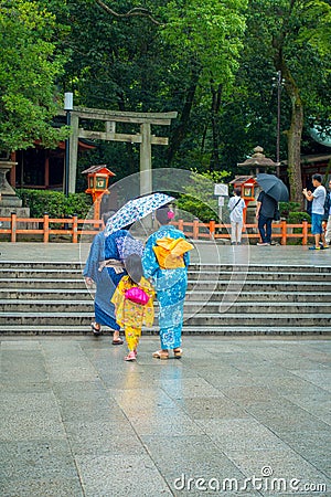 KYOTO, JAPAN - JULY 05, 2017: Young Japanese women wearing traditional Kimono and holding umbrellas in their hands in Editorial Stock Photo