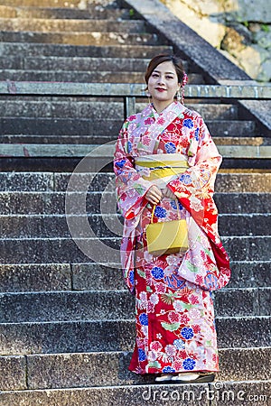 KYOTO, JAPAN - NOVEMBER, 8, 2019: Beautiful and Serene Japanese Lady Posing in Geisha Kimono On Shrine Stairway in Kyoto Streets, Editorial Stock Photo