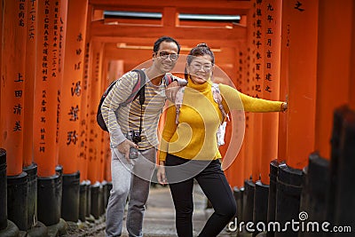 Kyoto japan - november9,2018 : couples asian tourist taking a photo in red wood pole of fushimi inari shrine fushimi inari is one Editorial Stock Photo