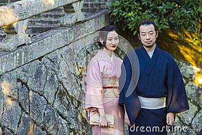 KYOTO, JAPAN - NOVEMBER, 8, 2019: Young Man and Woman Wearing Traditional Japanese Kimono Posing in Kyoto, Japan Editorial Stock Photo