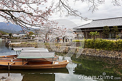 Kyoto, Japan, 04/06/2017: Traditional wooden Japanese boats on the river in a beautiful flowering spring nature. Holiday Hanami Editorial Stock Photo