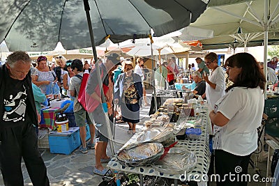 tourists of various nationalities shop in the characteristic market of typical products in Potamos, Greece Editorial Stock Photo