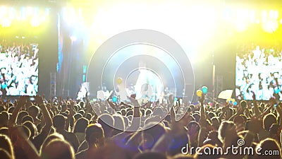 L'étape brillamment allumée à un concert, la foule, un grand nombre de personnes à un concert de rock, les mains augmentées des m clips vidéos L'étape brillamment allumée à un concert, la foule, un grand nombre de personnes à un concert de rock, les mains augmentées des m clips vidéos